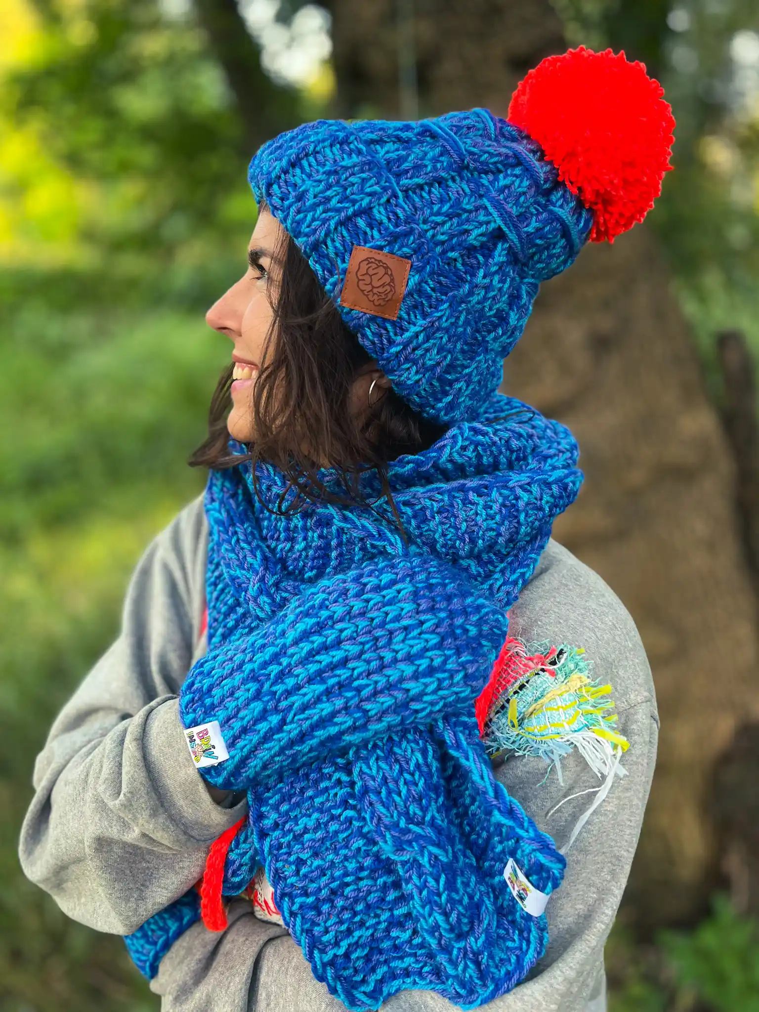 Czapka z wielkim pomponem MERINO 66% ,,Niebieskości" EUFORIA 15 Modna niebieska czapka z wyrazistym pomponem w pomarańczowym kolorze, wykonana przez seniorki z Poznania.